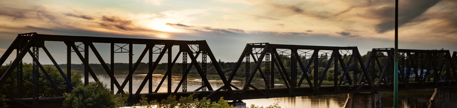 Train bridge over the river at sunset