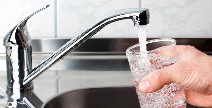 water from a faucet filling a cup