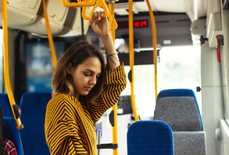 a lady using the handrail on a bus